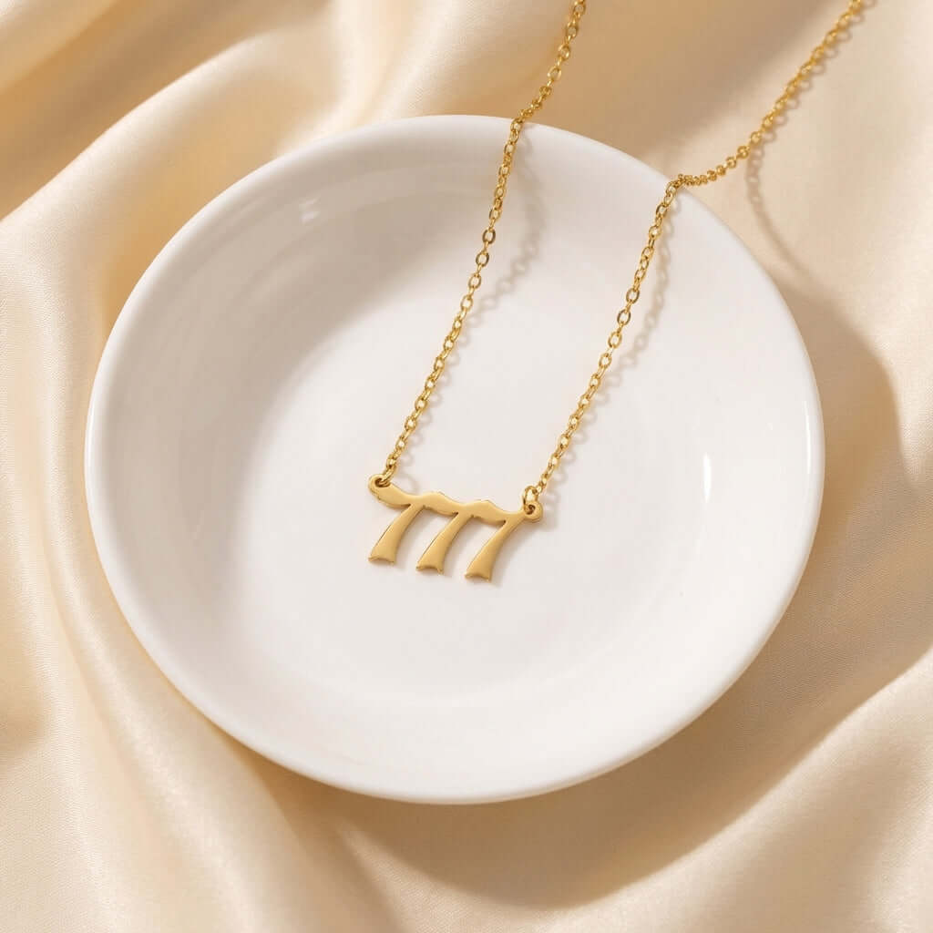 Angel Number Pendant Necklace by AUREATE displayed on a white plate, showcasing spiritual jewellery design.