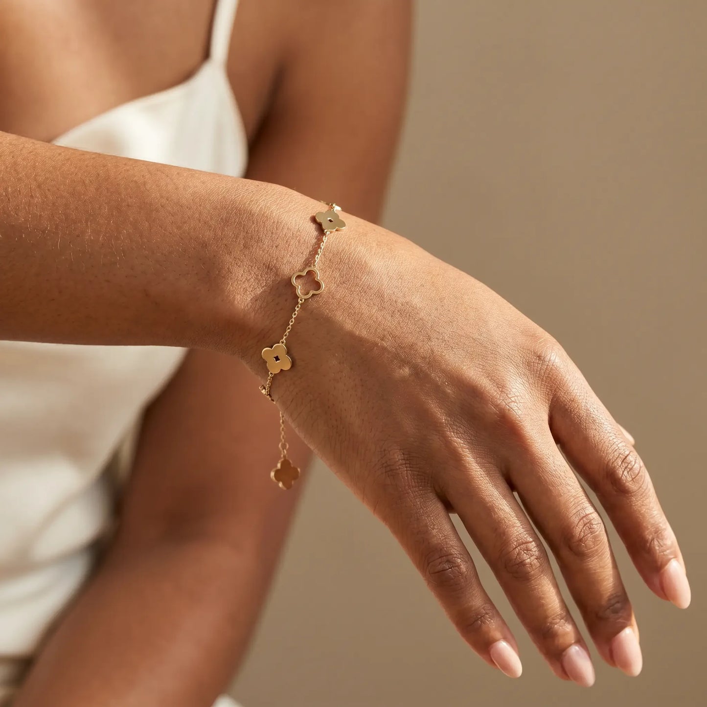 Four-leaf clover bracelet on dorsal wrist studio worn close-up - gold