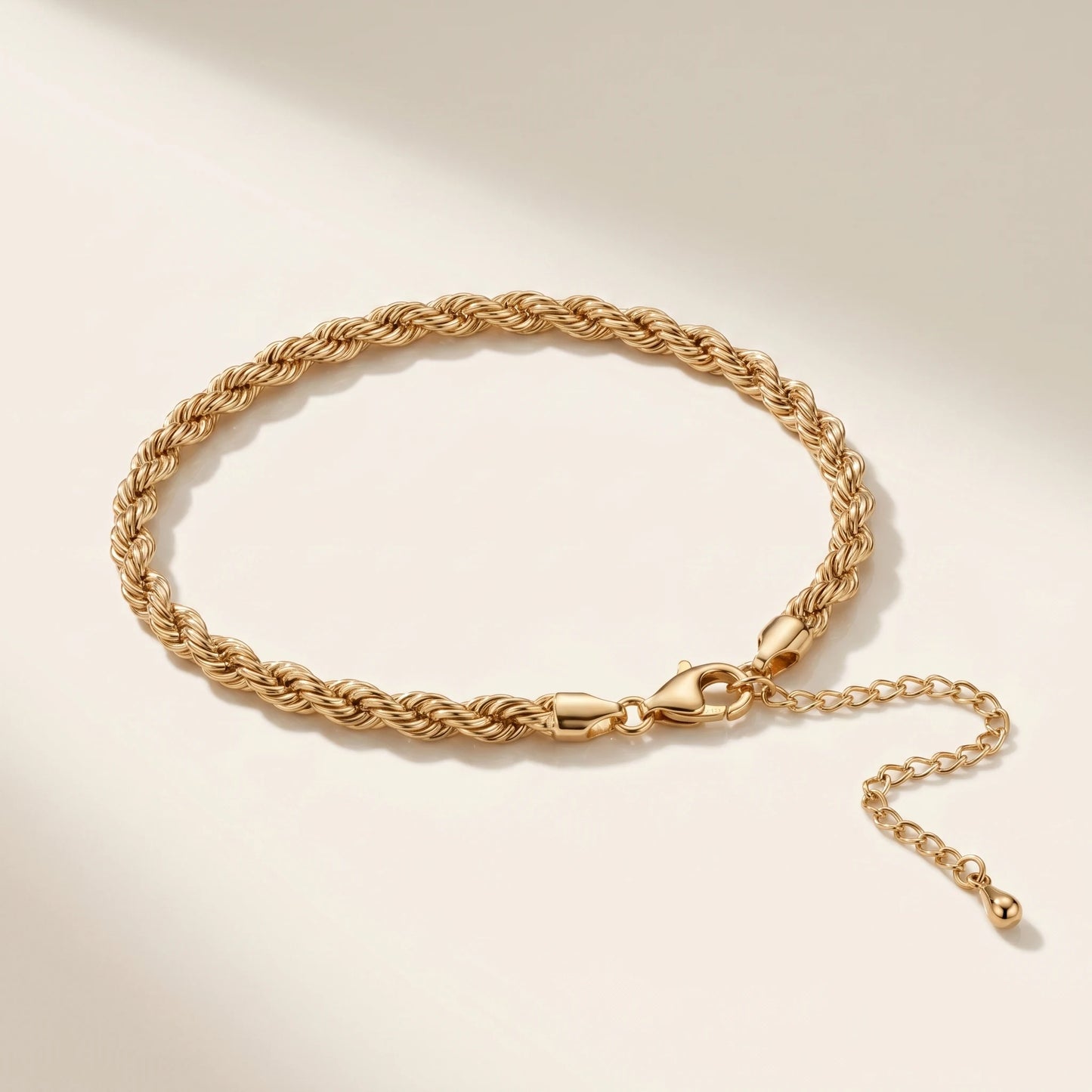 Bold gold rope chain anklet packshot on off-white background with lobster clasp and extension chain