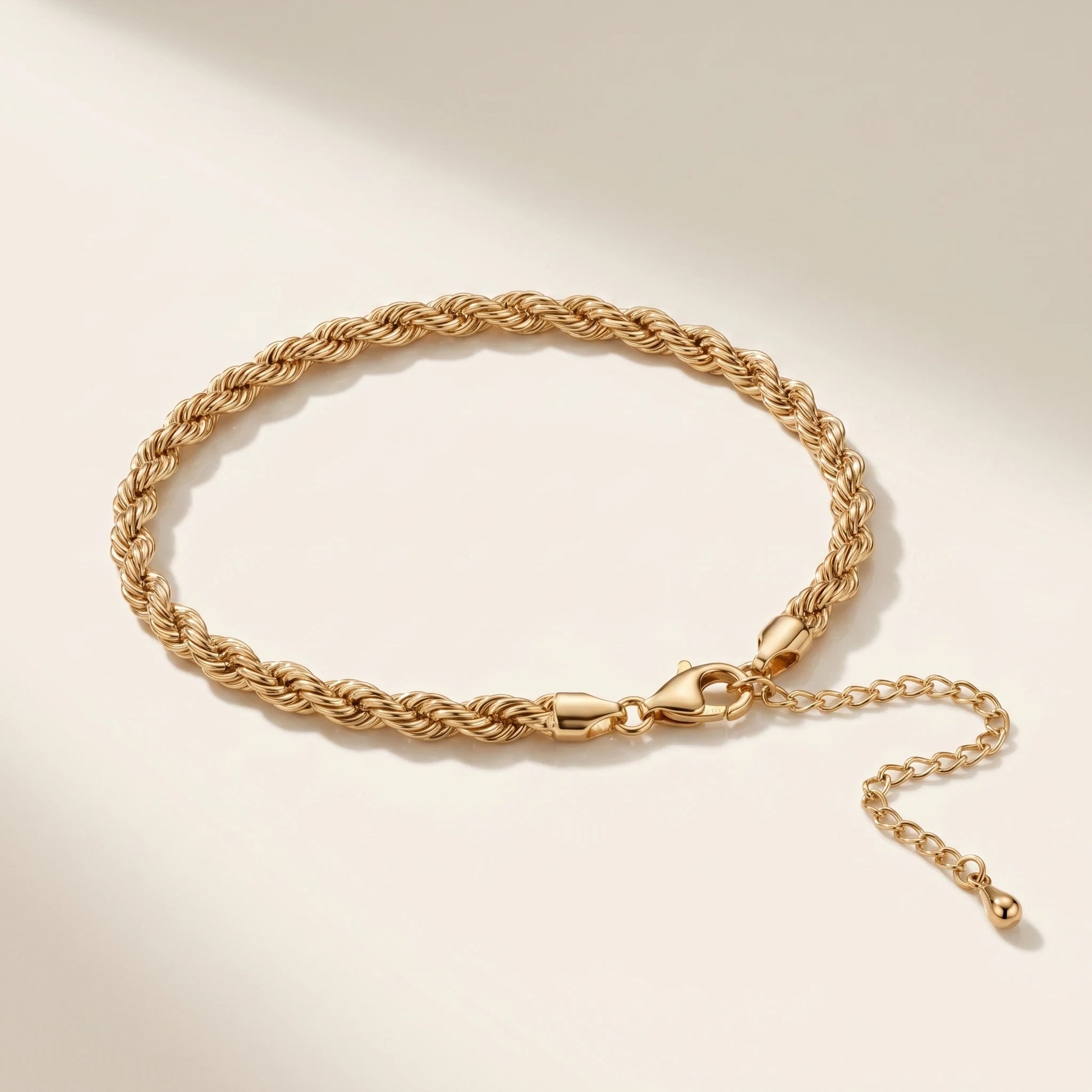 Bold gold rope chain anklet packshot on off-white background with lobster clasp and extension chain