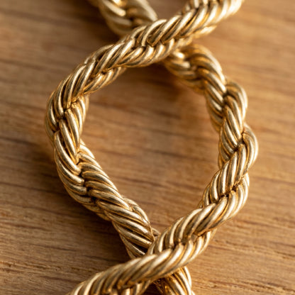 Macro detail of bold gold rope chain twist construction showing helical strands
