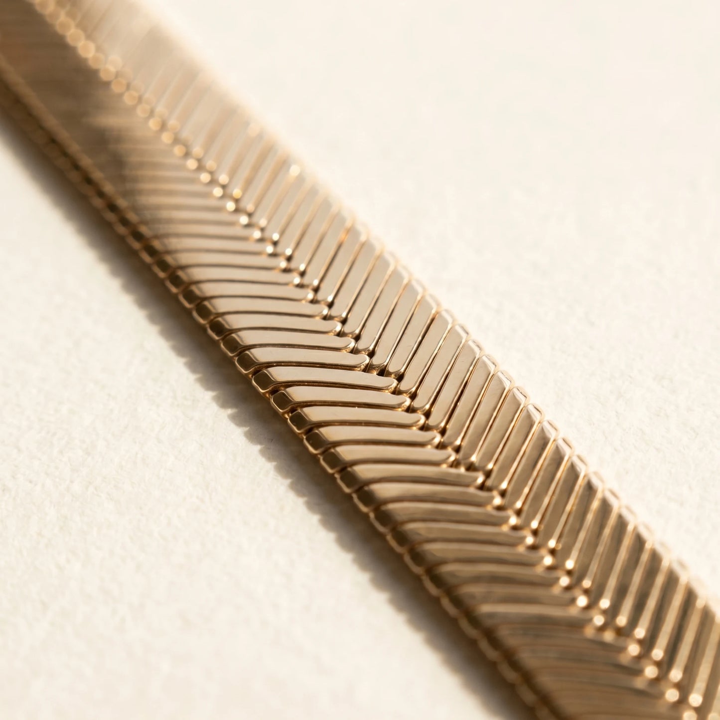 Gold herringbone flat chain anklet macro detail chevron V-pattern weave
