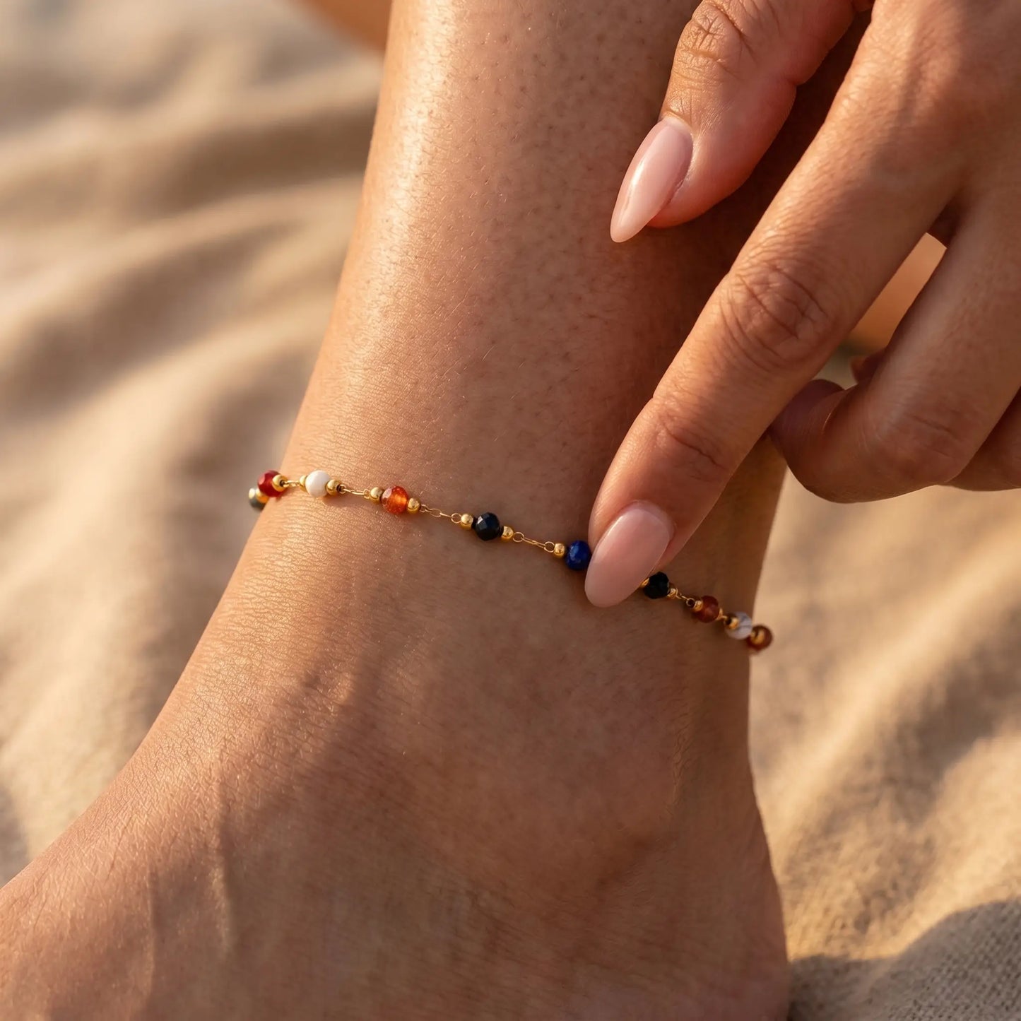 Hand fingertips touching multicolor beaded anklet on tanned ankle