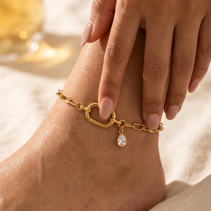Intimate close-up hand touching gold carabiner anklet on ankle daily ritual self-love