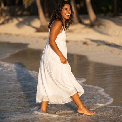 Bold gold rope anklet on barefoot Mexican-American woman walking through Tulum surf golden hour