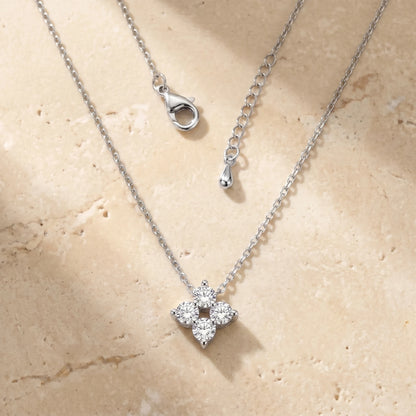 Diamond Cluster Necklace silver packshot — 4-stone CZ rhombus on warm travertine stone, dainty cable chain laid-flat, lobster clasp + teardrop extension visible