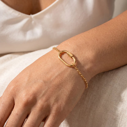 Oval lock cable bracelet gold 18K — worn dorsal wrist close-up