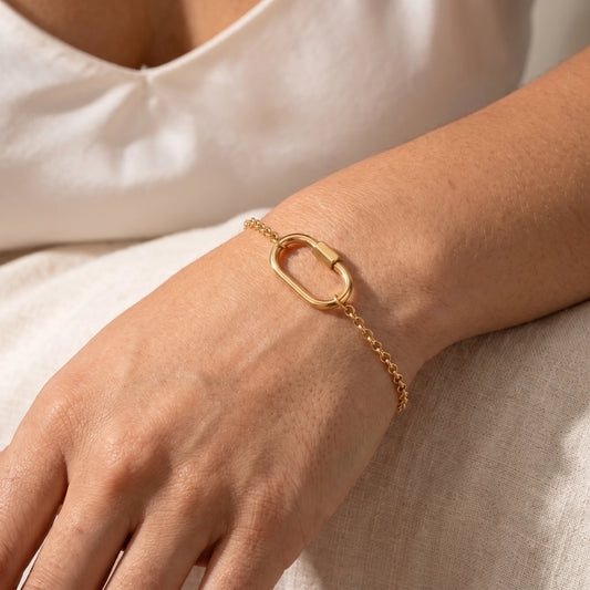 Oval lock cable bracelet gold 18K — worn dorsal wrist close-up