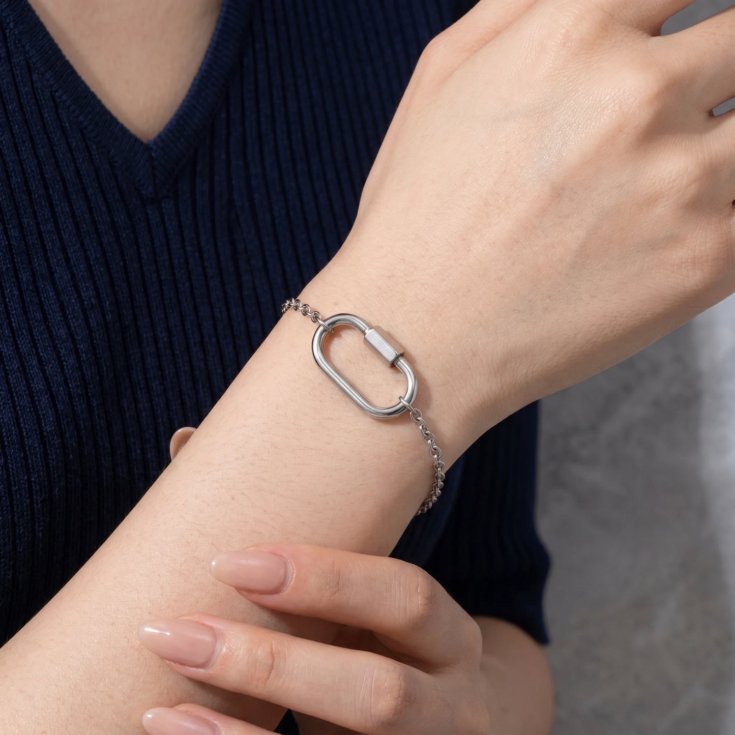 Oval lock cable bracelet silver — worn dorsal wrist close-up