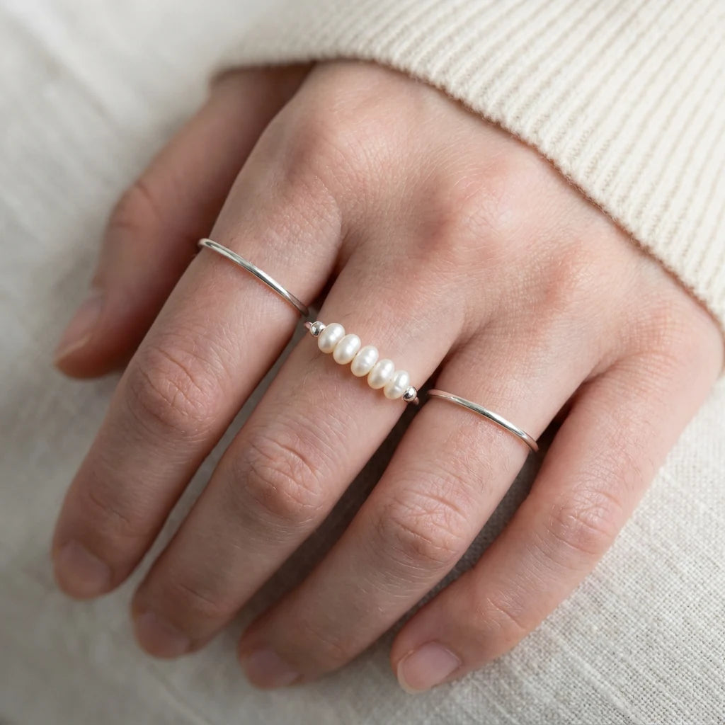 Silver Dainty Pearl Bar Ring stacked with plain silver bands on hand