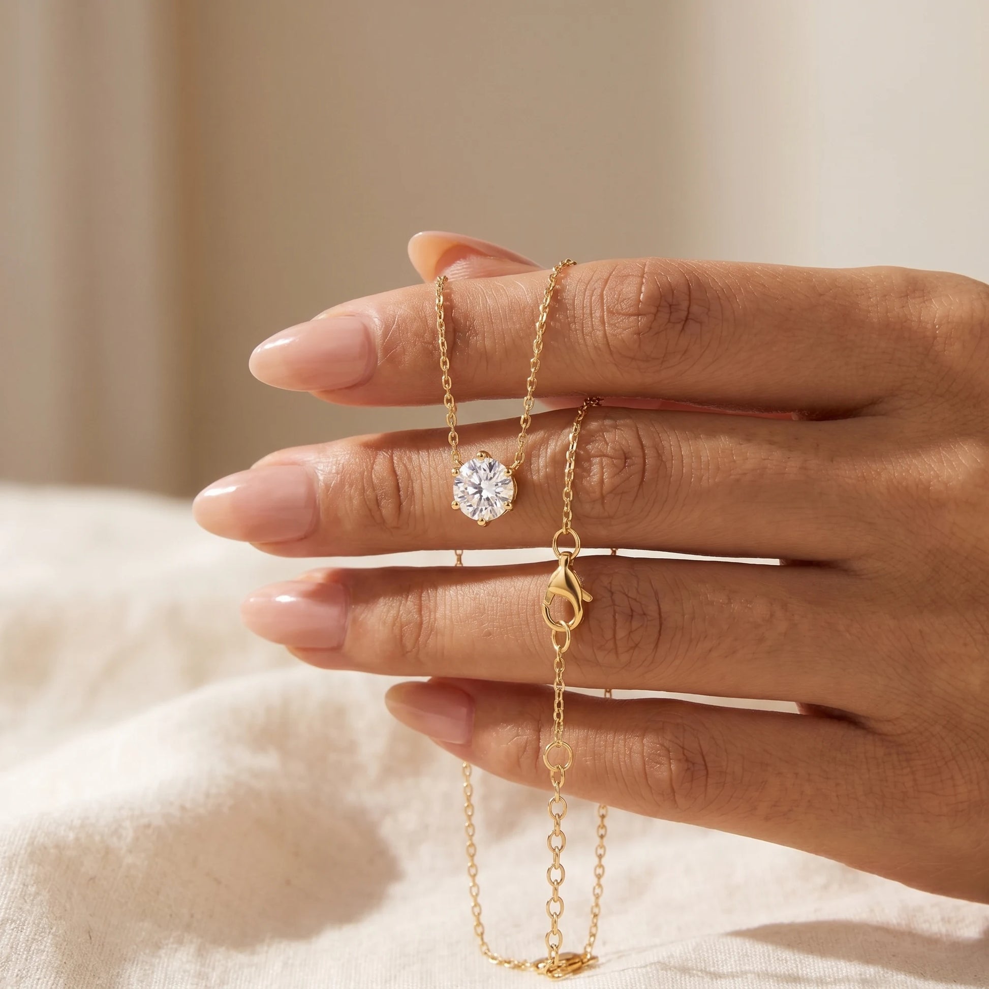 Floating Solitaire Necklace Gold held in hand - intimate close-up