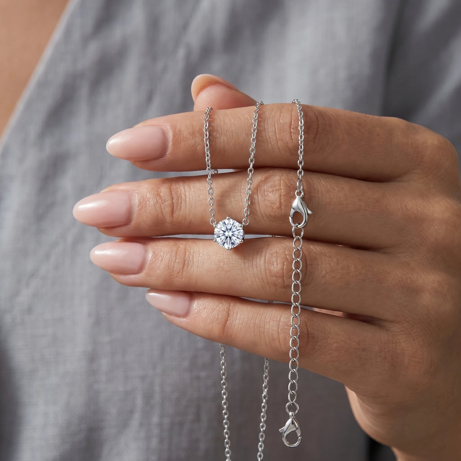 Floating Solitaire Necklace Silver Tone held in hand - intimate close-up