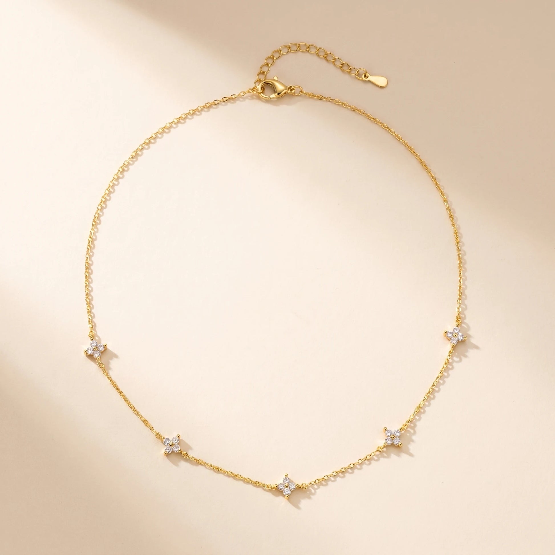 Gold clover station necklace packshot flat-lay 5 charms