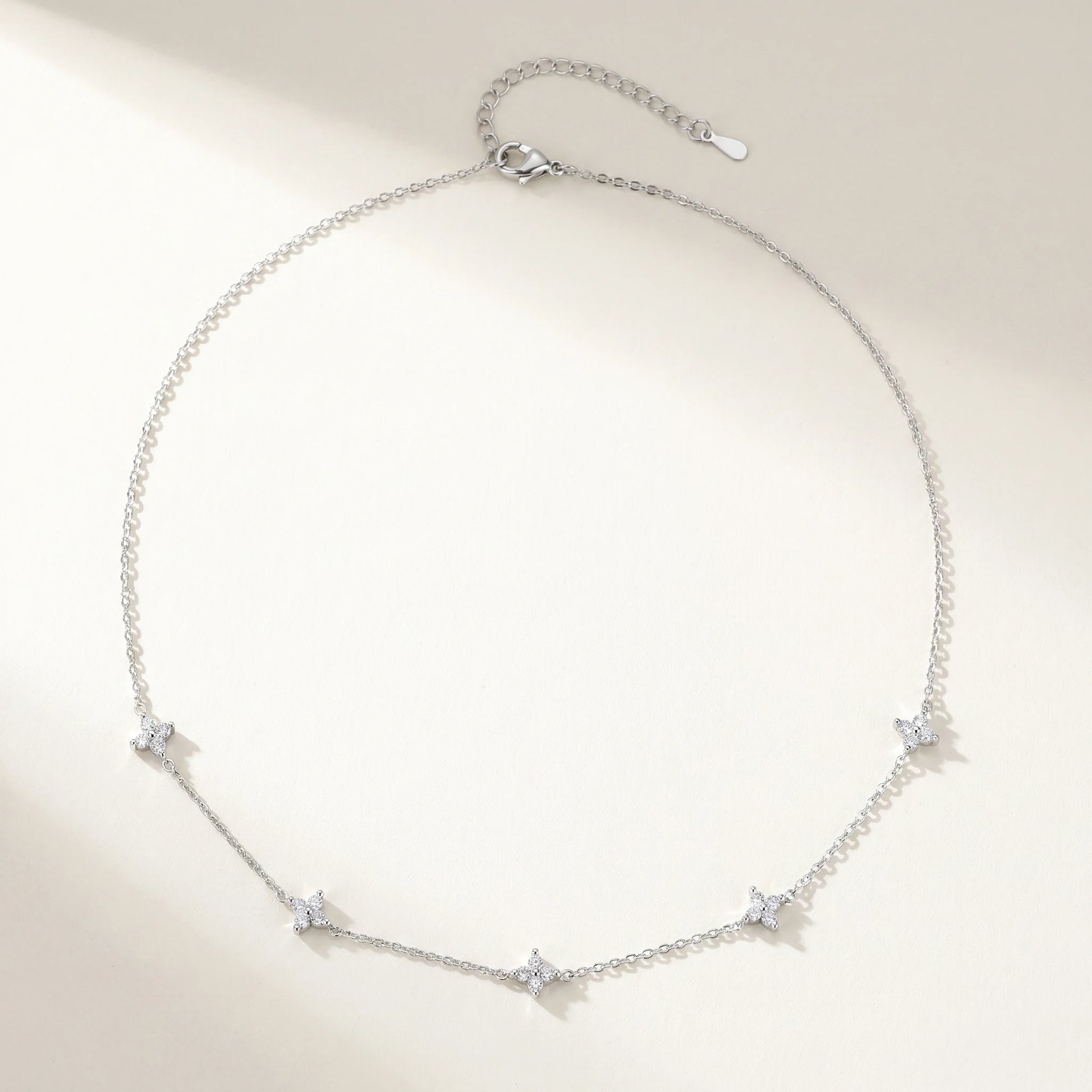 Silver clover station necklace packshot flat-lay 5 charms