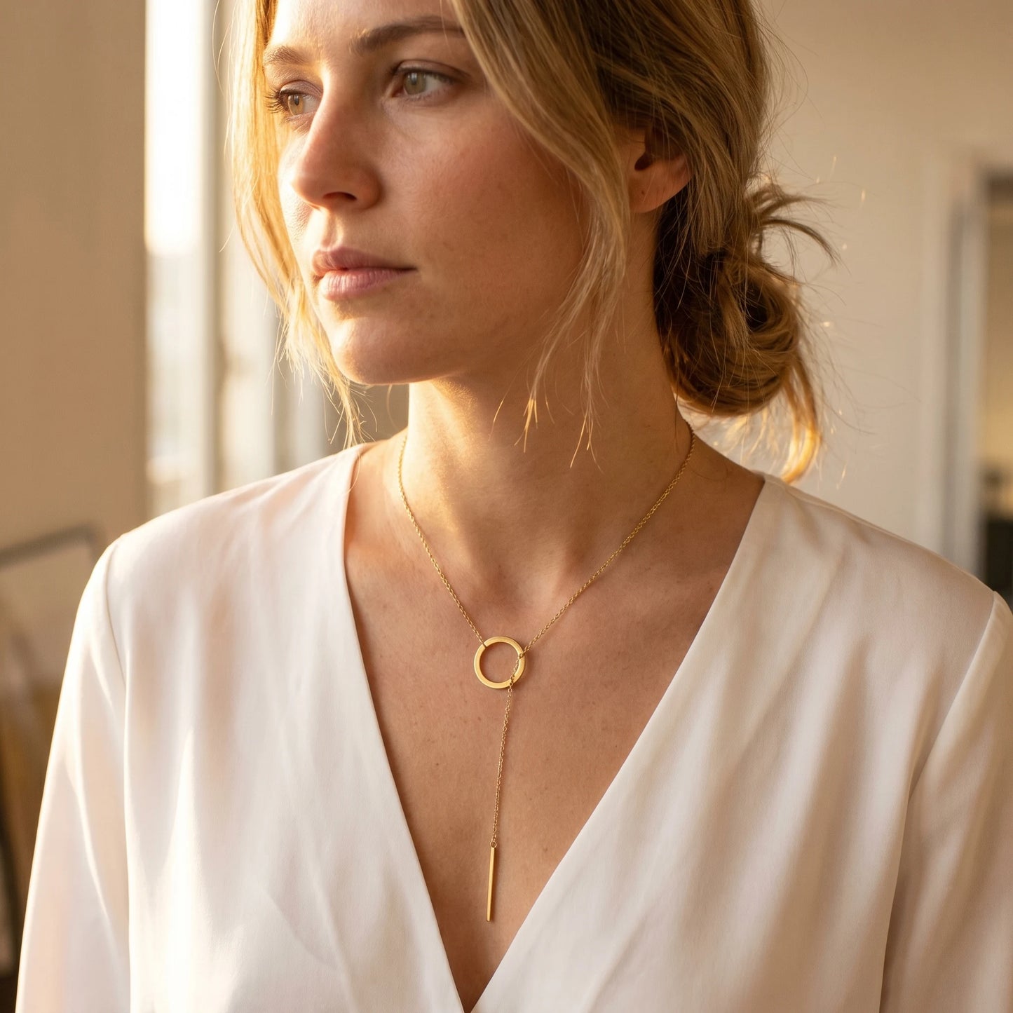 Gold Y-lariat necklace worn three quarter view editorial
