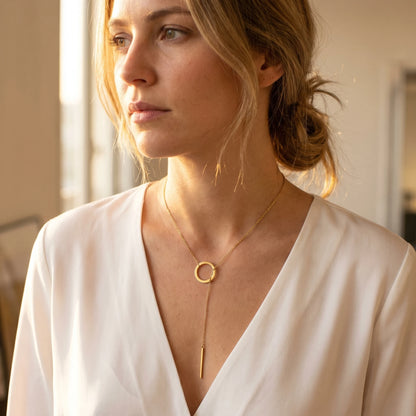 Gold Y-lariat necklace worn three quarter view editorial