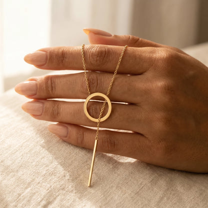 Gold Y-lariat necklace hand held intimate slip-through visible