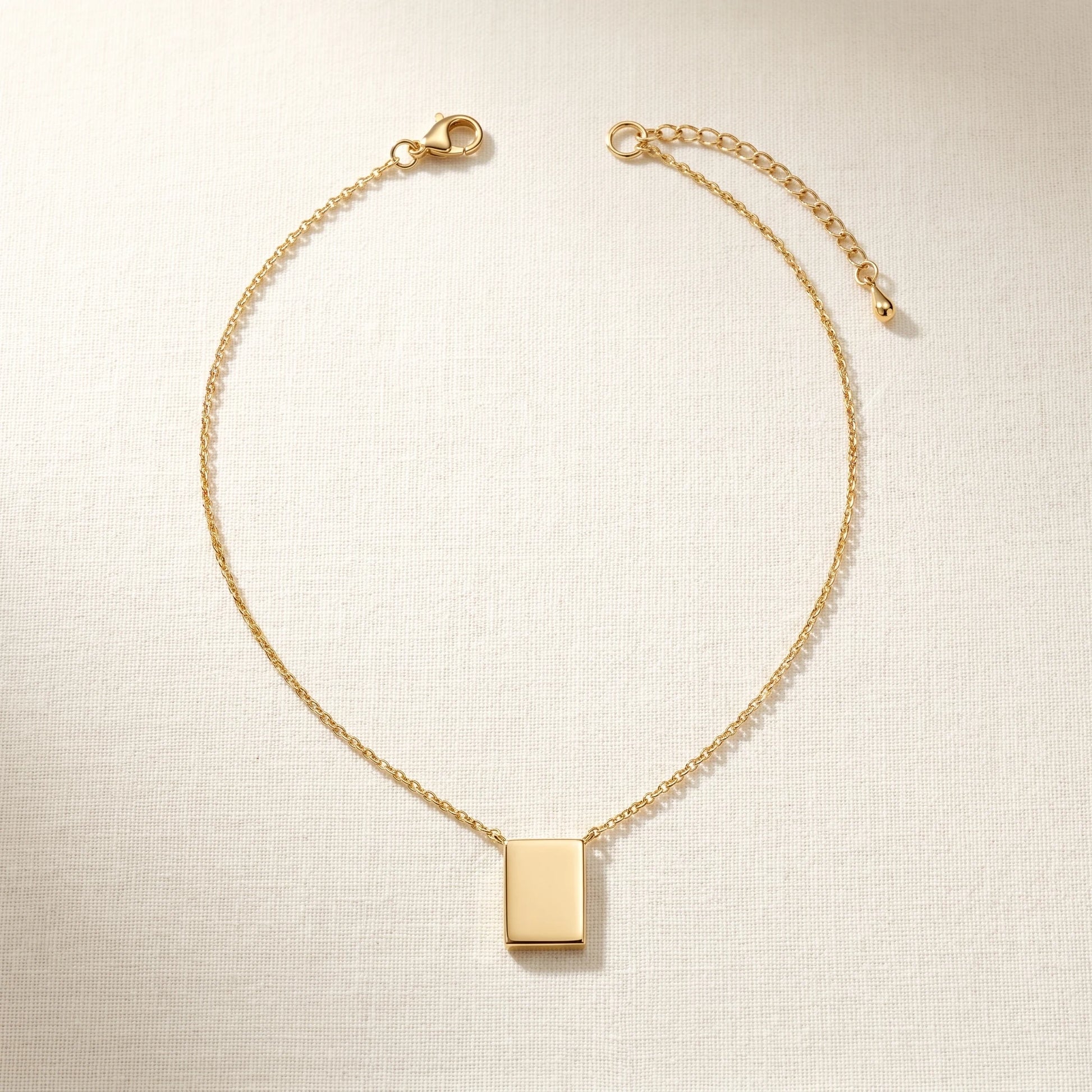 Gold rectangle pendant necklace packshot sharp corners extension chain properly attached