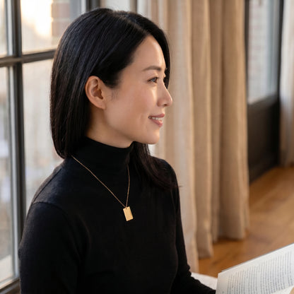 Gold rectangle pendant profile editorial subtle smile Tokyo morning
