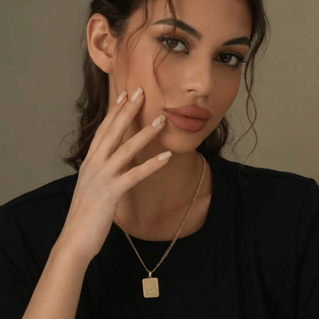 Embossed Initial Necklace with Cuban Chain worn by a model, showcasing the AUREATE brand's elegant design.