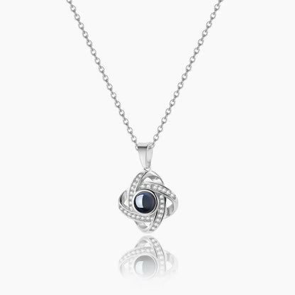 AUREATE Photo Projection Necklace featuring a unique design with sparkling accents and a dark center gem.