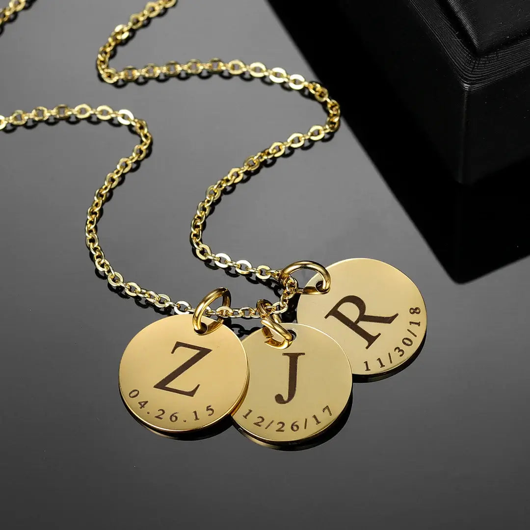 AUREATE Date & Initial Charm Necklace featuring engraved initials and dates on gold charms.