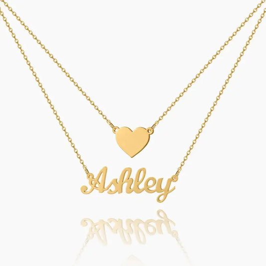 Layered Heart Name Necklace by AUREATE featuring a gold heart pendant and personalized nameplate 'Ashley'.