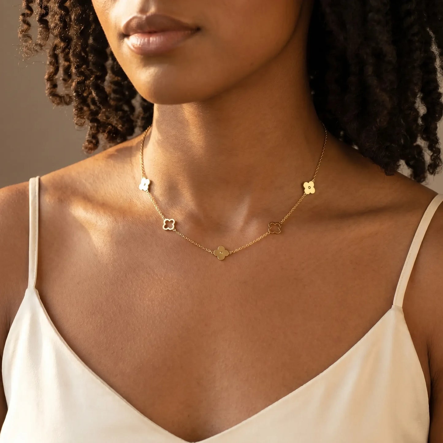 Four leaf clover necklace gold dainty worn close-up at collarbone