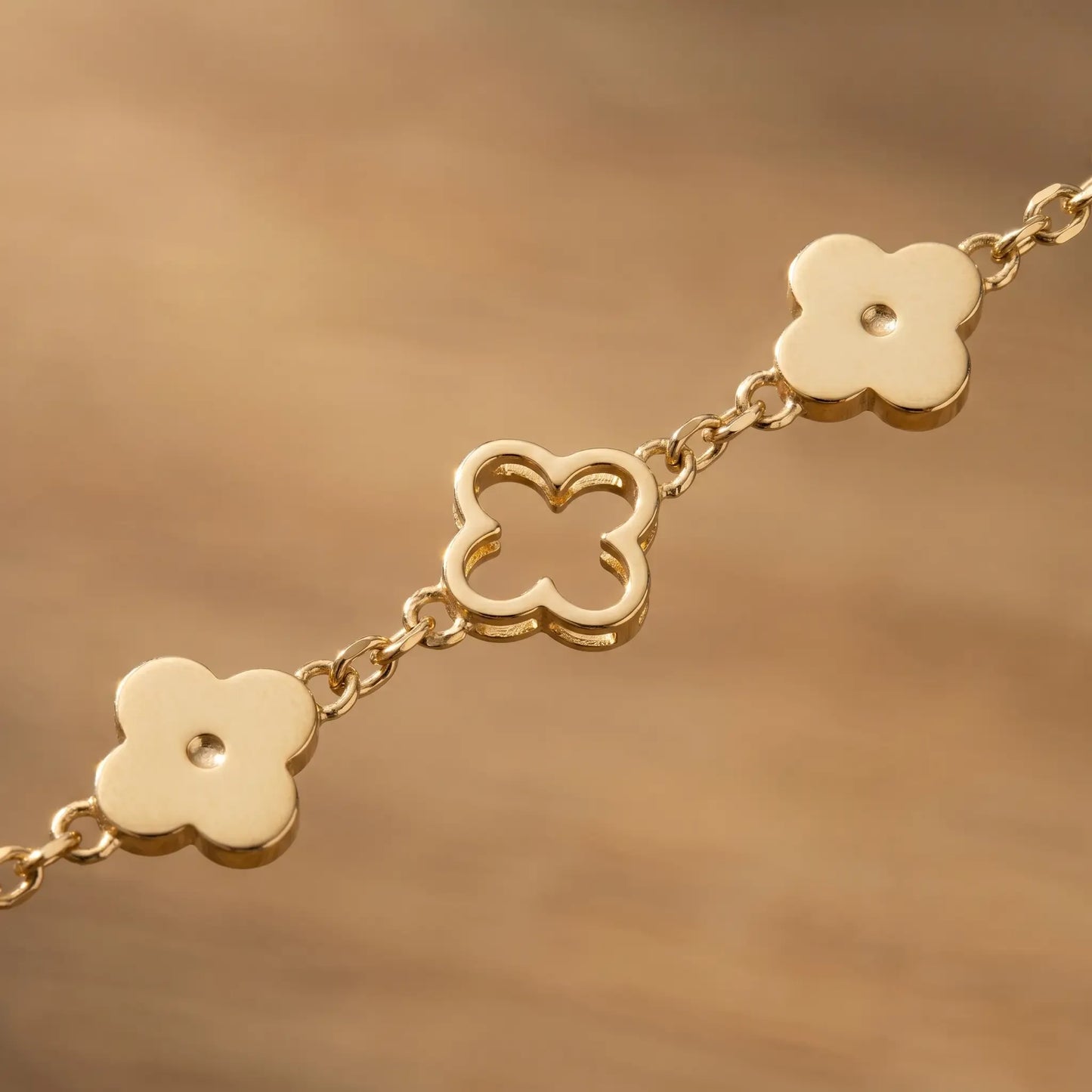 Four leaf clover necklace gold macro detail alternating solid outline clovers