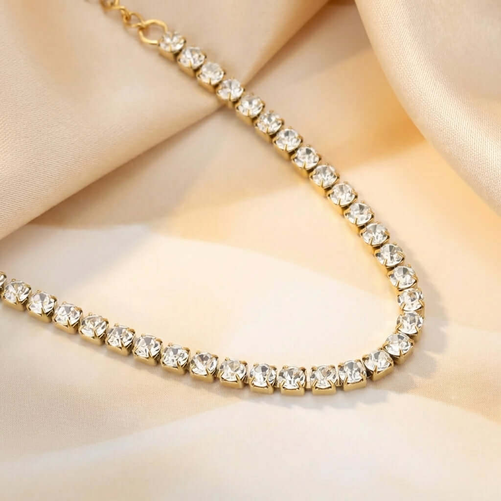 Classic Tennis Bracelet by AUREATE featuring a stunning line of clear crystals on a gold chain, embodying luxury.