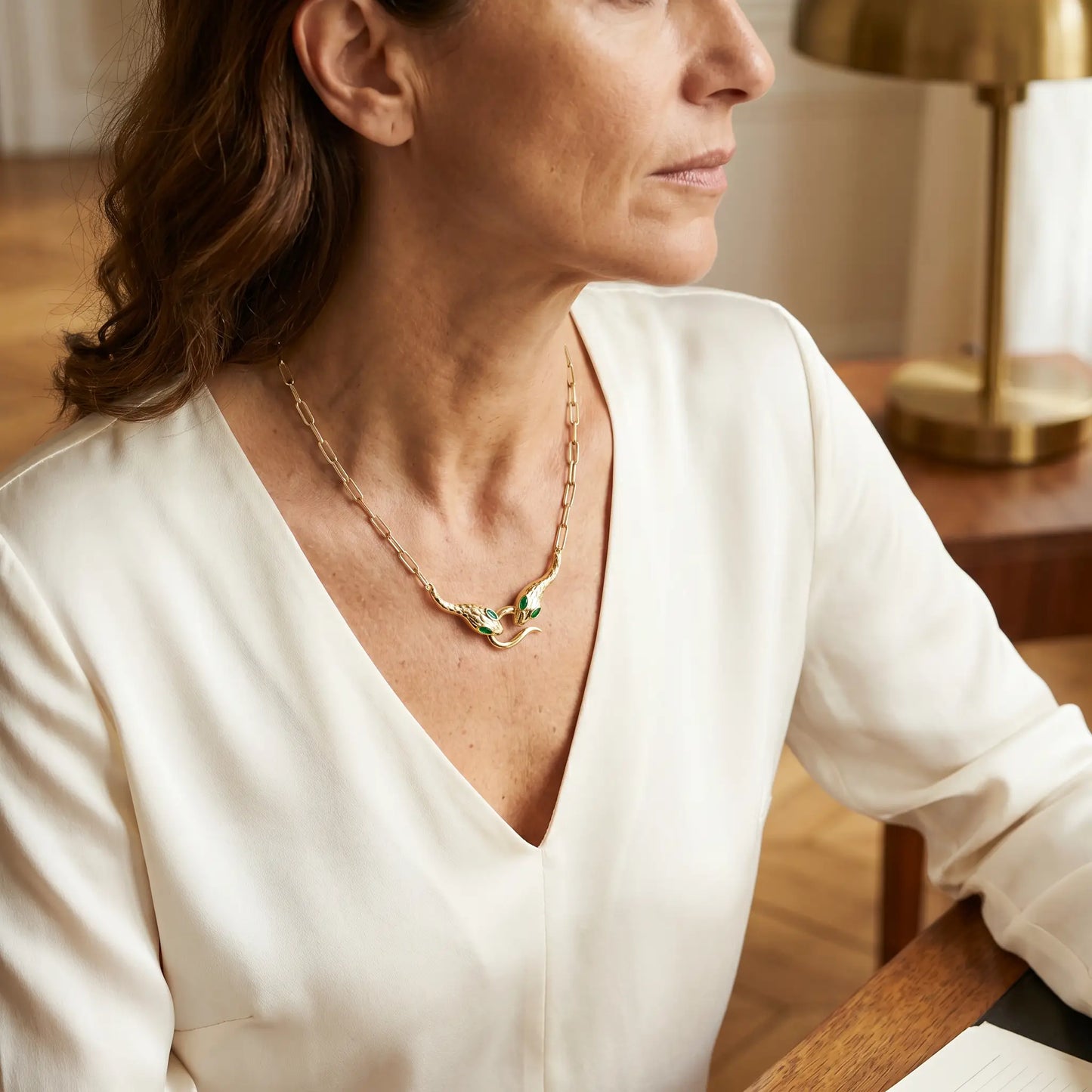 Snake pendant necklace mature elegance studio portrait - gold serpent choker ivory blouse