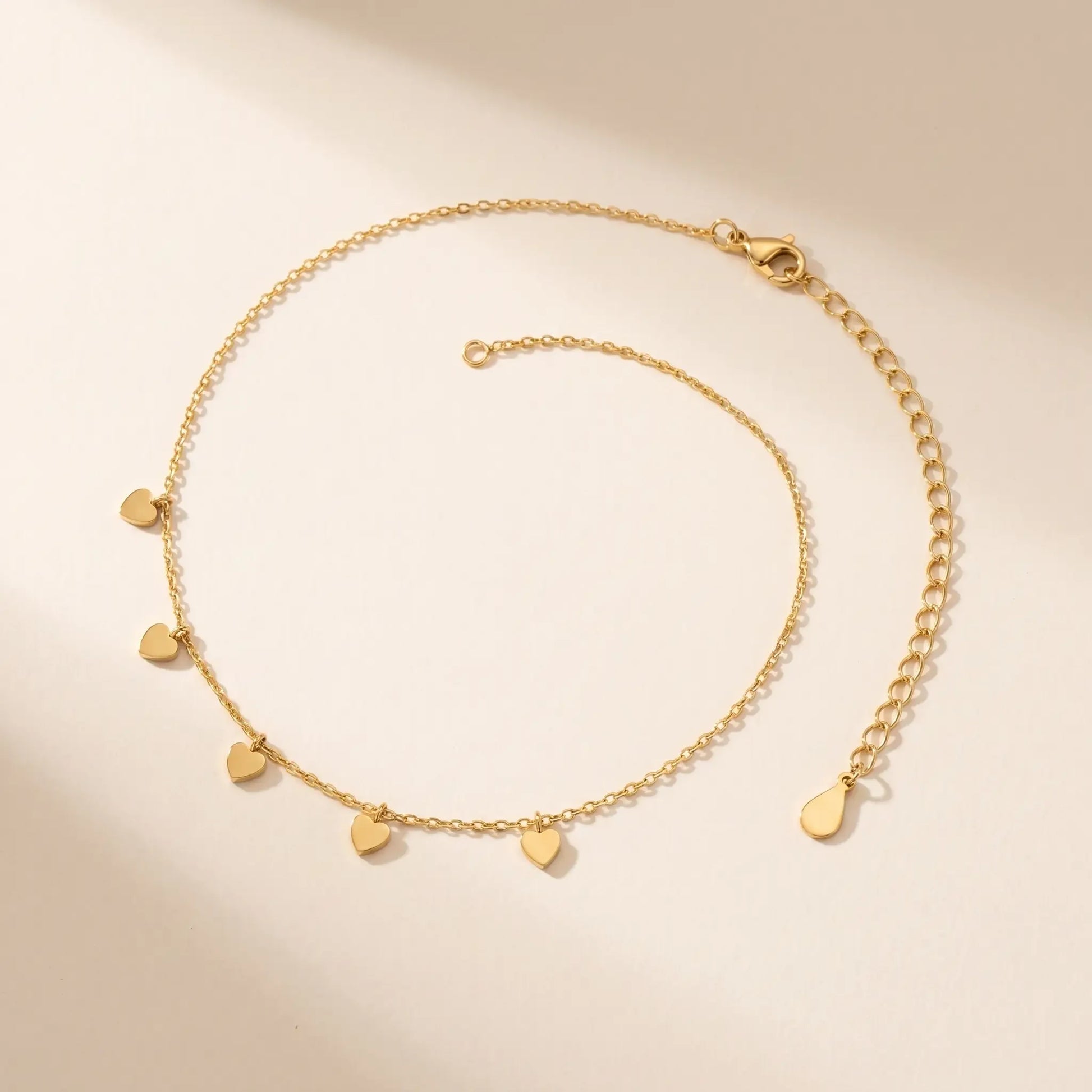 Tiny gold heart drop anklet packshot dainty wire-thin chain with five hearts