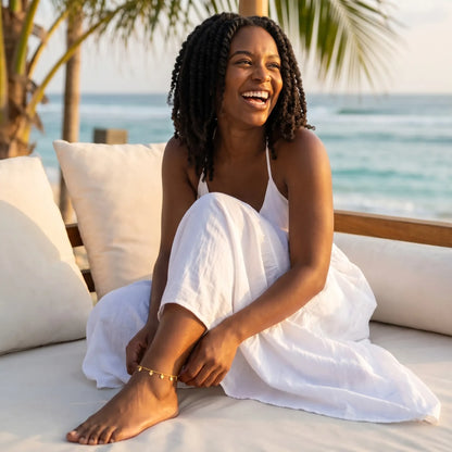 Joy half-laugh lifestyle at Bali beach club daybed wearing tiny gold heart drop anklet