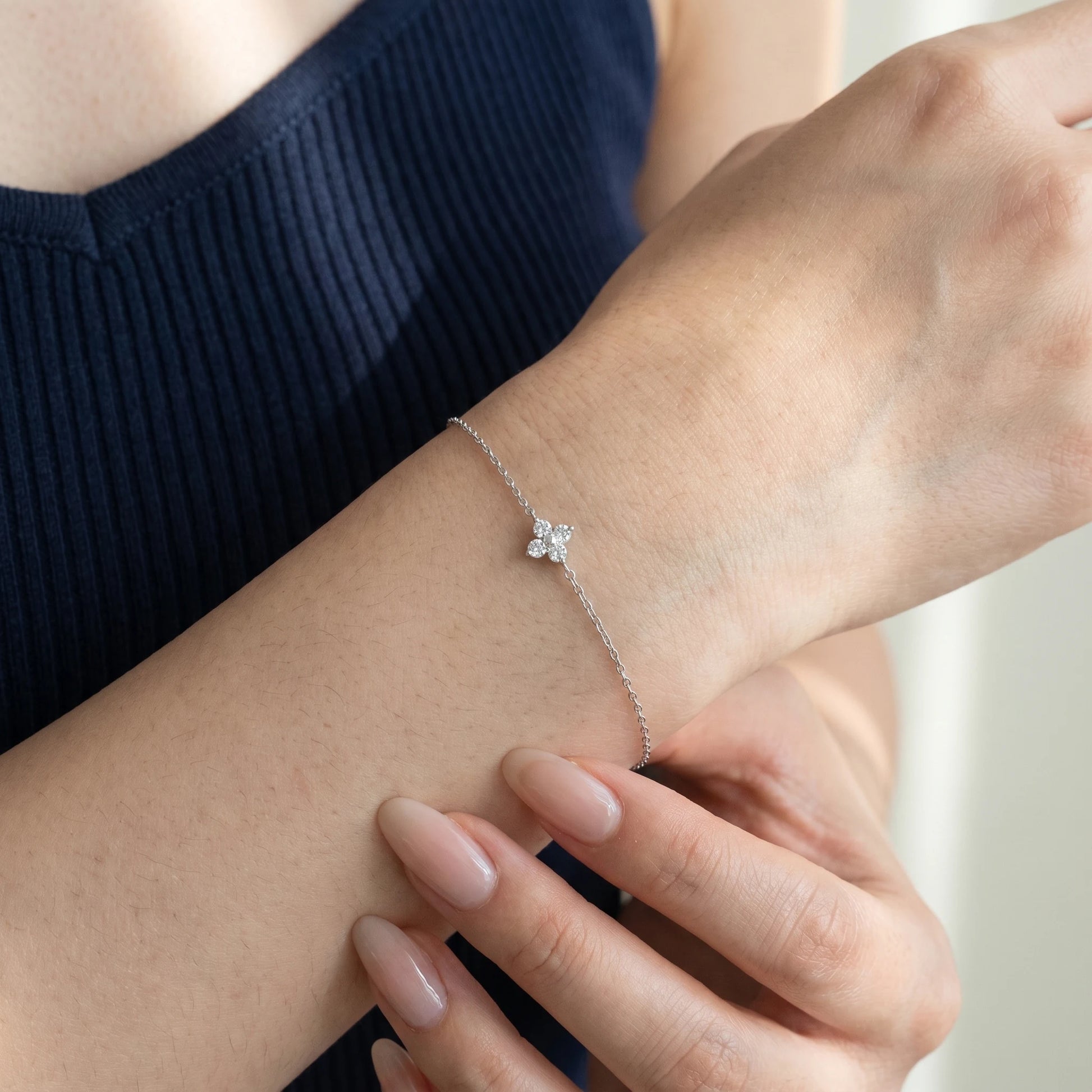 Silver solitaire four leaf clover bracelet worn close-up dorsal wrist