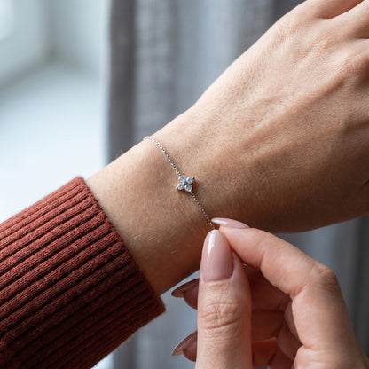 Dainty silver clover bracelet intimate hand-to-jewelry fingertips touching