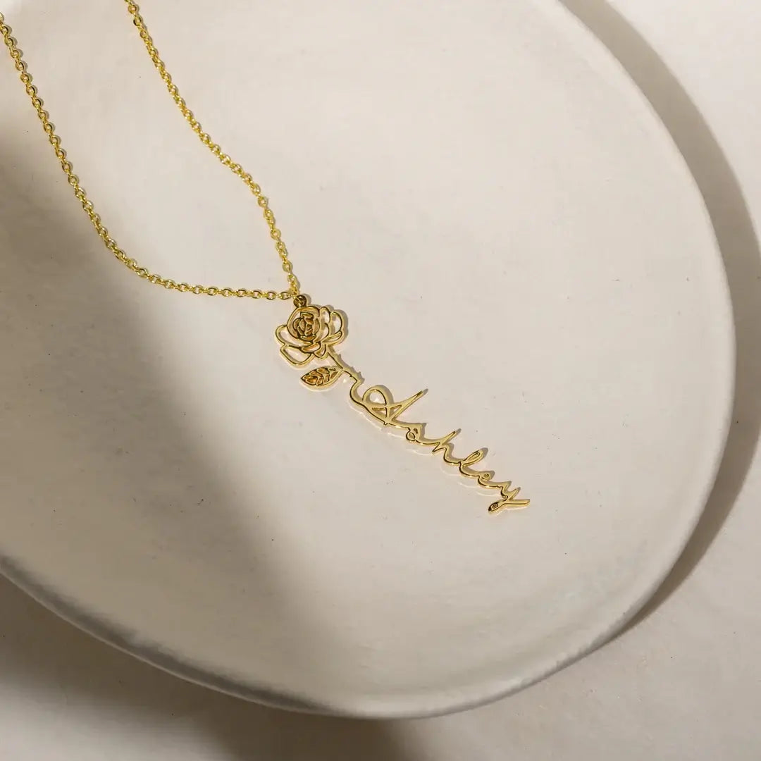Name Necklace with Birth Flower from AUREATE featuring a golden personalized design with a floral charm.