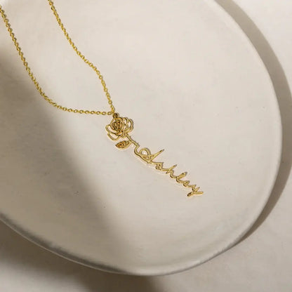 Name Necklace with Birth Flower from AUREATE featuring a golden personalized design with a floral charm.