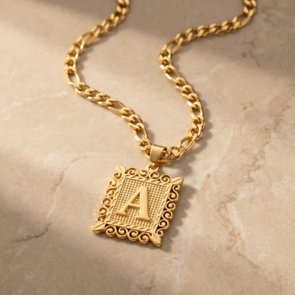 Raised Initial Figaro Pendant 18K gold packshot on travertine