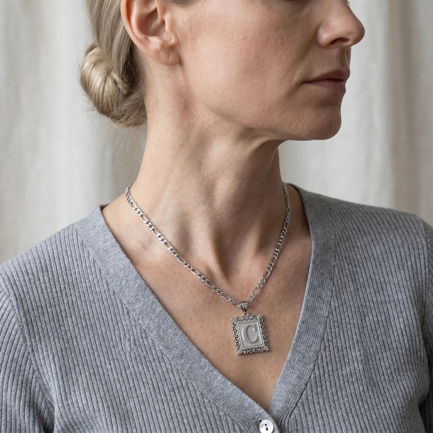 Raised Initial Figaro Pendant silver tone worn 3/4 profile mature