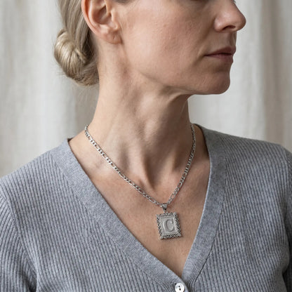 Raised Initial Figaro Pendant silver tone worn 3/4 profile mature