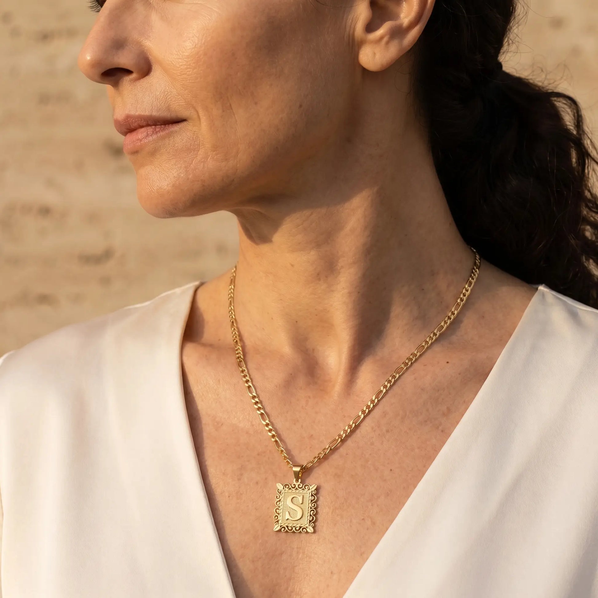 Raised Initial Figaro Pendant 18K gold worn 3/4 profile mature elegance