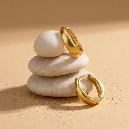 18K gold plated chunky dome hoop earrings, still life on smooth stones | SKU: AUR-CHKDOM-G