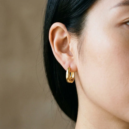 18K gold plated chunky dome hoop earrings, worn close up on the ear