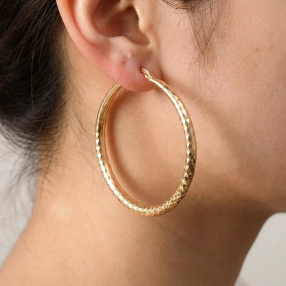 18K gold plated diamond cut large hoop earrings, macro detail on the earlobe | SKU: AUR-DCTHOP-G