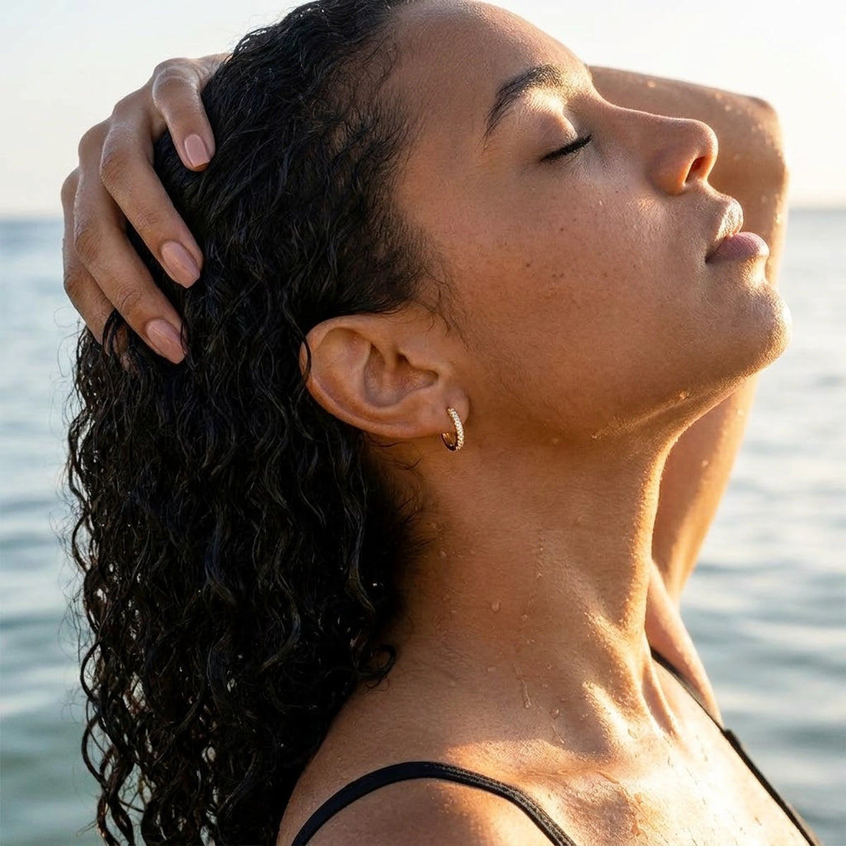 18K gold plated pave huggie hoop earrings, worn in the water at golden hour | SKU: AUR-PVHUGG-G