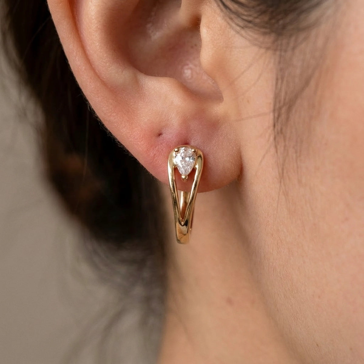 18K gold plated pear cut crystal huggie hoop earrings, macro detail on the earlobe | SKU: AUR-PRCZHG-G