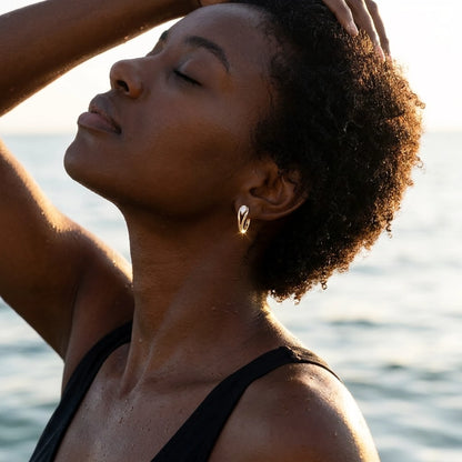 18K gold plated pear cut crystal huggie hoop earrings, worn in the water at golden hour | SKU: AUR-PRCZHG-G