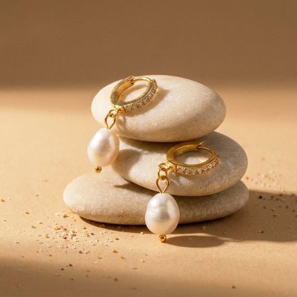 18K gold plated freshwater pearl drop huggie earrings, still life on smooth stones | SKU: AUR-PRLHUG-G