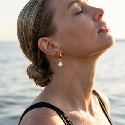 18K gold plated freshwater pearl drop huggie earrings, worn in the water at golden hour | SKU: AUR-PRLHUG-G