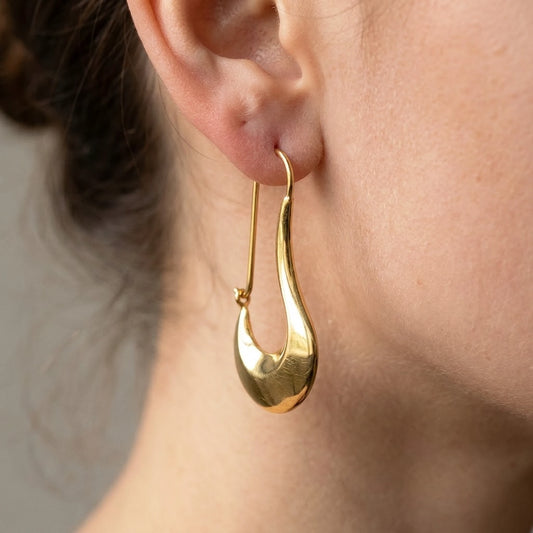 18K gold plated sculpted crescent drop earrings, macro detail on the earlobe | SKU: AUR-SCPCRS-G